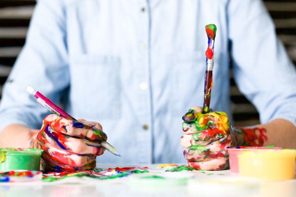 2. Idei de pictura pentru copii - tehnici pentru toate vârstele - maini pline de culoare, sprijinite pe masa, camasa albastra